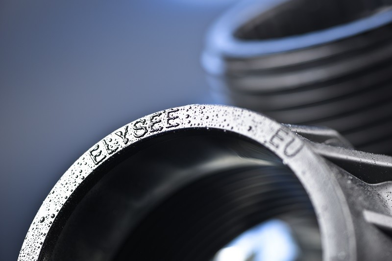 Operator inspecting injection-moulded fittings on the production floor