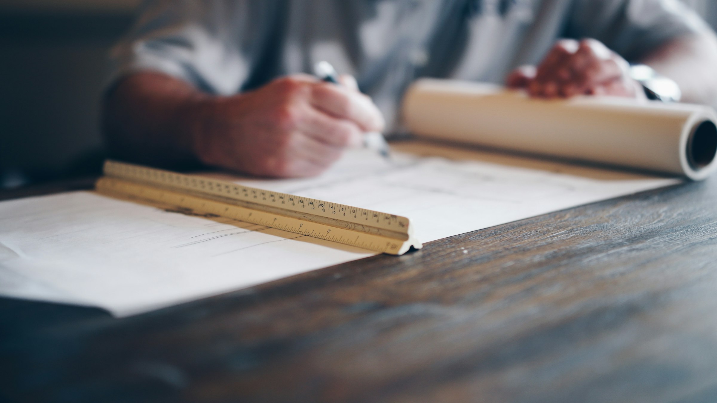 An engineer drafting technical plans on a blueprint.